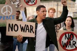 Bezpłatne zdjęcie młodzi ludzie biorący udział w protestach antywojennych