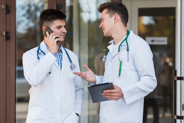 Młodzi medycy rozmawiają przy drzwiach