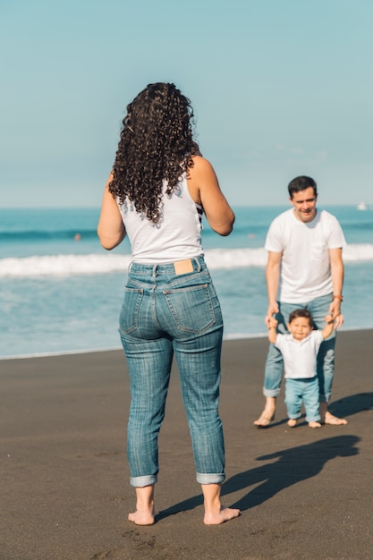 Bezpłatne zdjęcie młodzi rodzice bawić się z dzieckiem na plaży