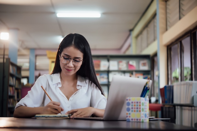 Młodzi studenci uczący się, regały biblioteczne