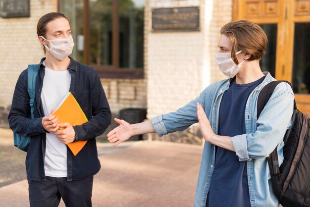 Młodzi studenci z maskami na uniwersytecie