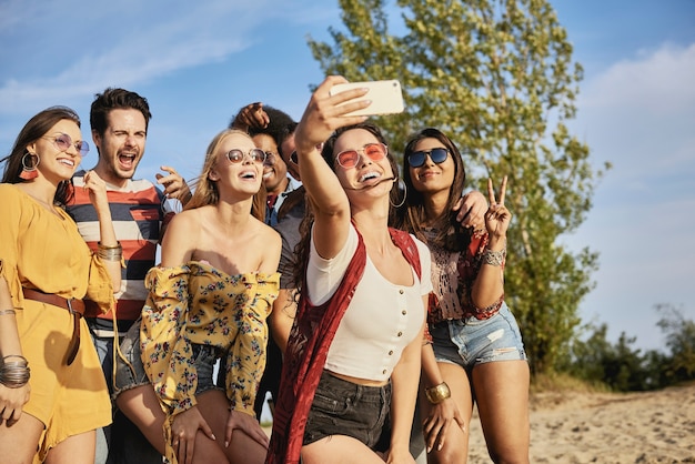 Młodzi uśmiechnięci ludzie robiący selfie