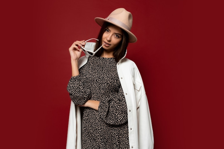 Bezpłatny plik Zdjęcie moda piękny portret eleganckiej brunetki kobiety ubrany biały płaszcz i beżowy kapelusz trzymając okulary przeciwsłoneczne. modny styl jesień lub zima.