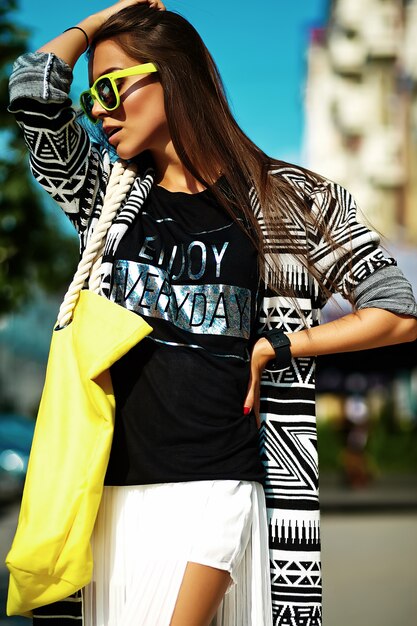 moda stylowa piękna młoda brunetka kobieta model w lecie hipster kolorowe ubranie pozowanie na tle ulicy
