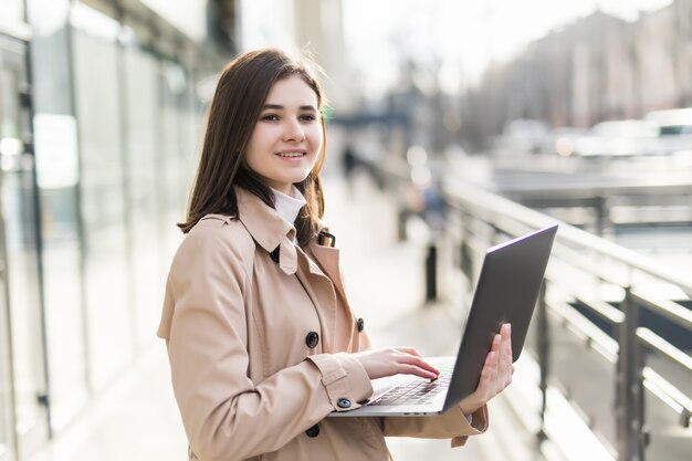 Model brunetka pracuje na swoim nowym laptopie w centrum handlowym