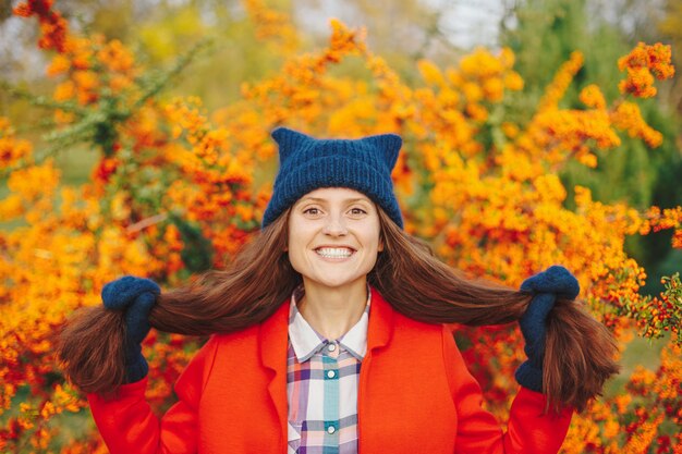 Model ma na sobie stylowy czapka zimowa i rękawiczki z uśmiechem