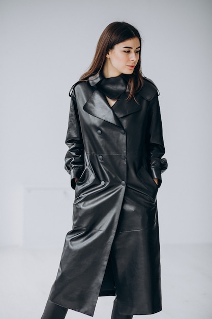 Model młodej kobiety na sobie długi czarny skórzany płaszcz