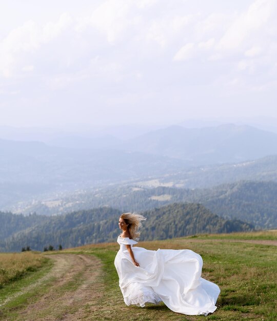 Modelka w sukni ślubnej pozuje w górach