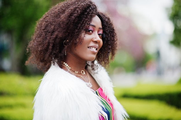 Modna Afroamerykanka W Różowym Kombinezonie W Paski Z Puszystym Sztucznym Futrem Pozowana Na Wiosennej Ulicy