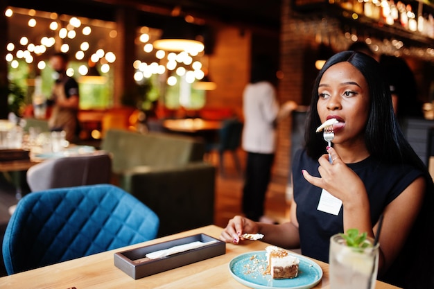 Modne Feministyczne Afroamerykanki Ubierają Się W Czarną Koszulkę I Szorty Pozowane W Restauracji Jedzą Sernik