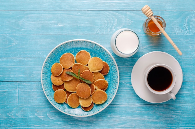 Modne jedzenie - mini pancake płatki. Sterta naleśników zbożowych z jagodami i orzechami.