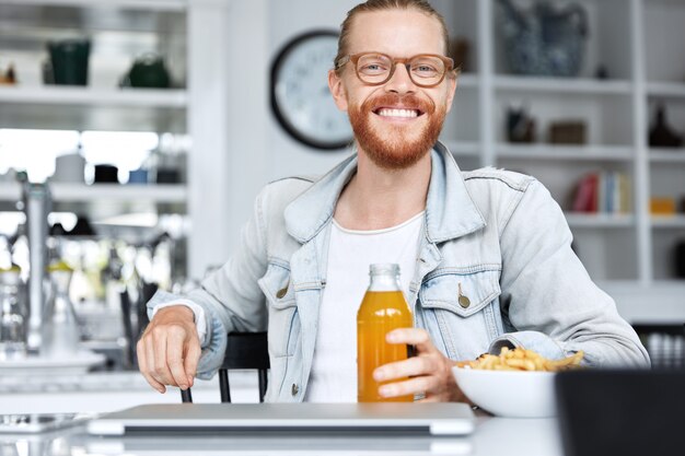 Modny hipster facet ubrany w dżinsową koszulę i stylowe okulary