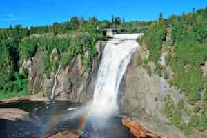 Bezpłatne zdjęcie montmorency falls z tęczą i błękitnym niebem w pobliżu quebec city.