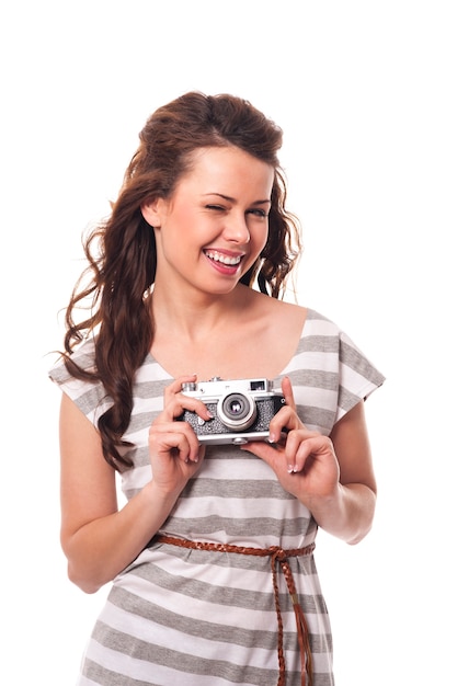 Mrugając kobieta trzyma aparat retro