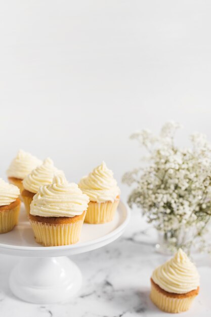 Muffins na tortowym stojaku przeciw białemu tłu