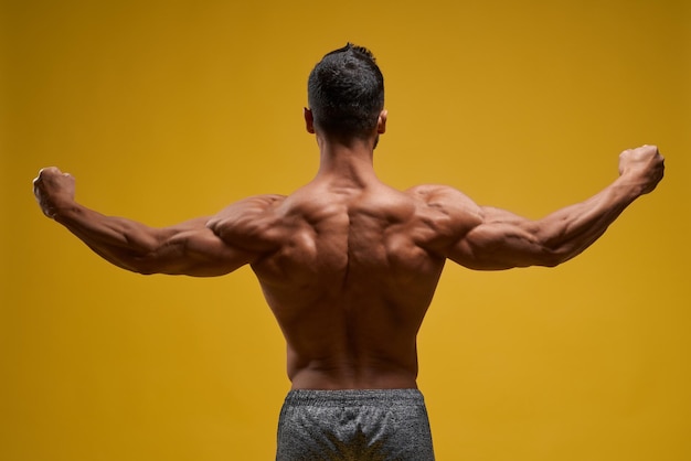Bezpłatne zdjęcie muskularny młody mężczyzna pokazujący idealne bicepsy