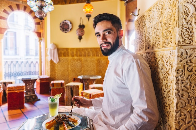 Bezpłatne zdjęcie muzułmanin człowiek siedzi w restauracji