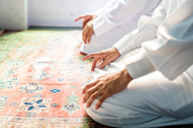 Muzułmańscy mężczyźni modlący się w postawie tashahhud