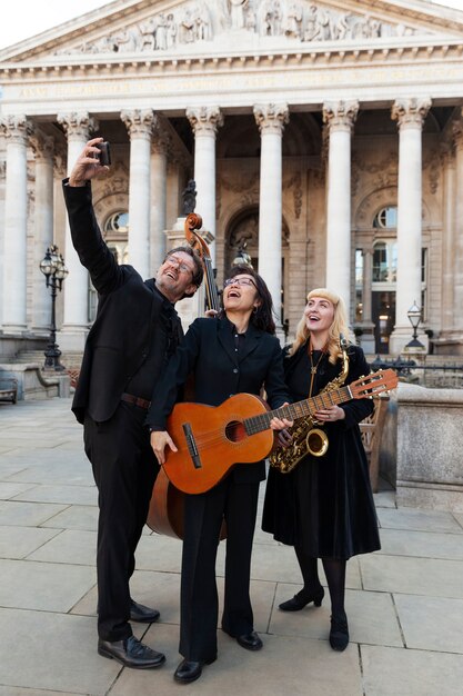 Muzycy w pełnym ujęciu robiący selfie na świeżym powietrzu