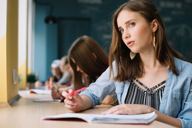 Myślenie schoolgirl spojrzenie na aparat fotograficzny