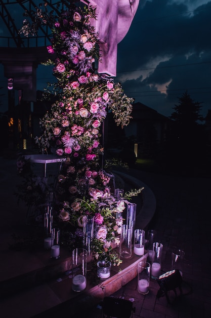 Na zewnątrz kompozycja wykonana z róż i zieleni ze świecami oświetlanymi w nocy