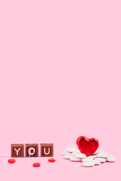 Bezpłatne zdjęcie napis na kawałkach czekolady i sercu ozdobnym