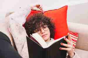 Bezpłatne zdjęcie nastolatka czytanie na kanapie