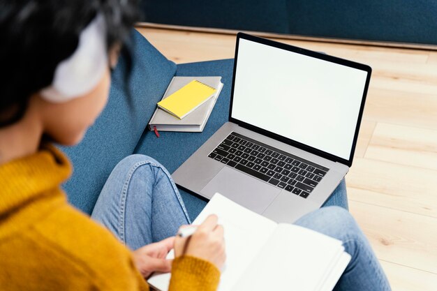 Nastolatka ze słuchawkami i laptopem podczas szkoły online