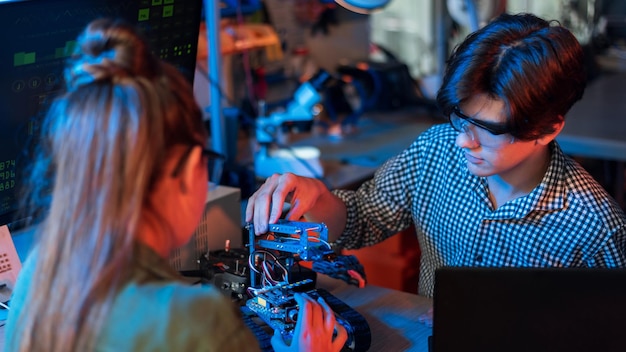 Bezpłatne zdjęcie nastolatki robi eksperymenty w robotyce w laboratorium chłopiec i dziewczynka w pracy okulary ochronne