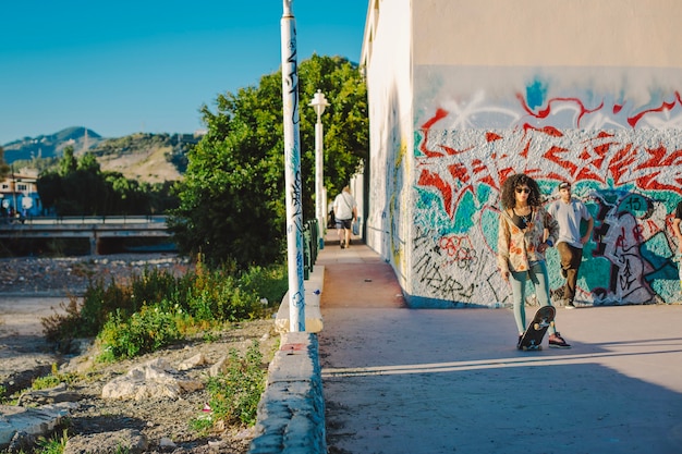 Bezpłatne zdjęcie nastolatki skateboarding w backstreet