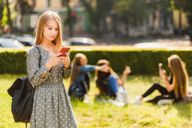 Nastoletnia dziewczyna używa smartphone w parku