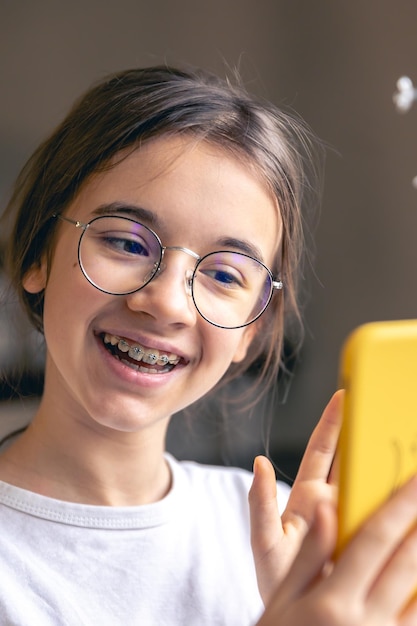 Bezpłatne zdjęcie nastoletnia dziewczyna w okularach i szpilkach komunikuje się za pośrednictwem rozmowy wideo