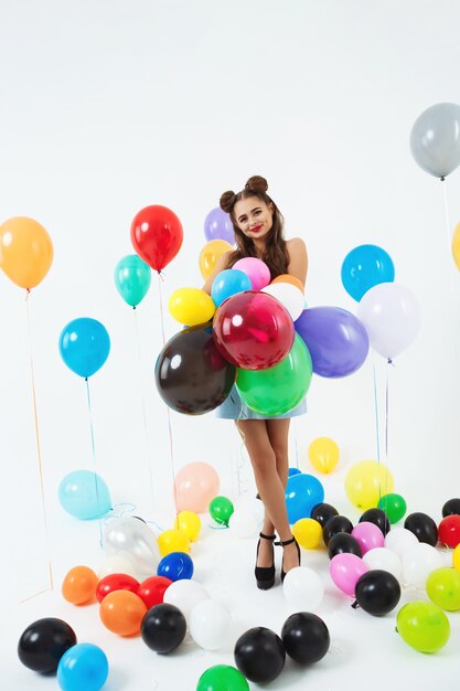 Nastoletnia dziewczyna w pin-up ubraniach trzyma wiązkę balony