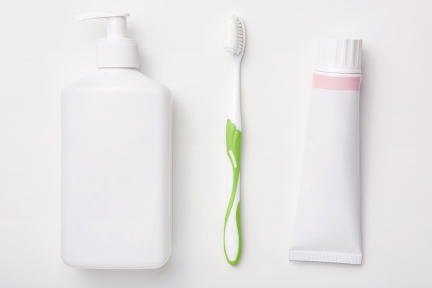 Naturalne produkty kosmetyczne izolowanych na białej ścianie Pasta do zębów, szczoteczka do zębów i butelka kremu. Koncepcja piękna. Higiena