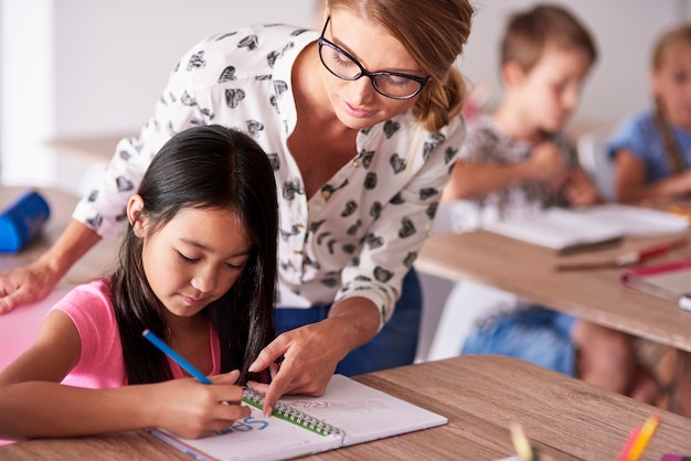 Nauczyciel pomaga dziewczynie w odrabianiu prac domowych