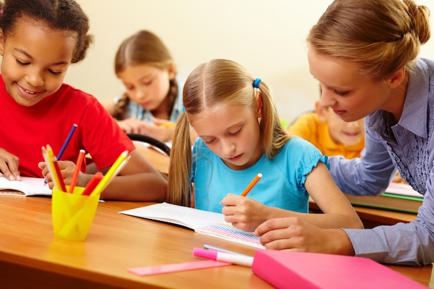 Nauczyciel pomaga student z pracy pisemnej