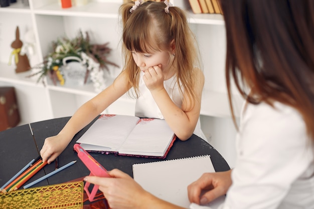 Bezpłatne zdjęcie nauczyciel z małą dziewczynką studiującą w domu