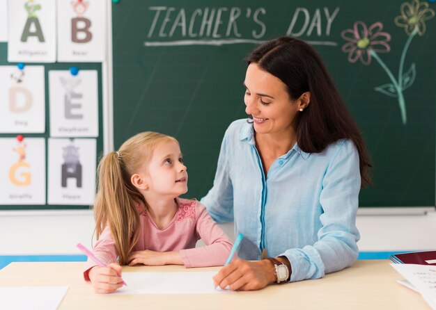 Nauczycielka patrząc na swojego małego ucznia