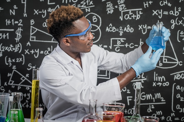 Naukowcy patrzą na błękitne chemikalia w szkle w laboratorium