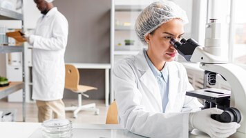 Naukowcy w laboratorium biotechnologicznym z tabletem i mikroskopem