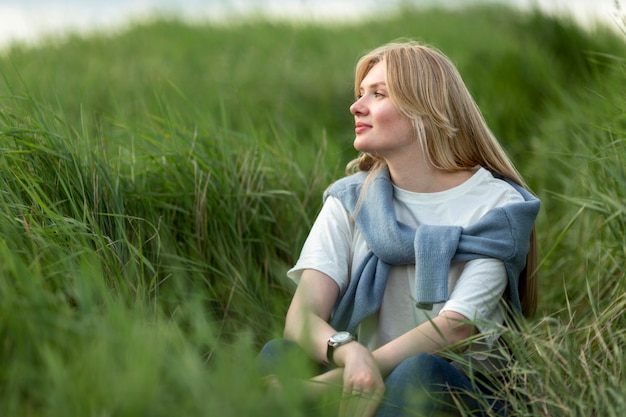 Nęcąca kobieta pozuje w trawie
