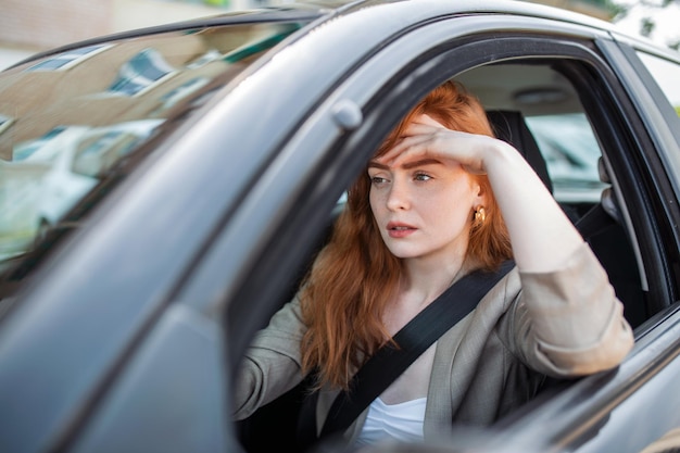 Bezpłatne zdjęcie nerwowa kierowca siedzi za kierownicą ma zmartwioną minę, bo boi się po raz pierwszy samodzielnie prowadzić samochód przestraszona kobieta ma wypadek samochodowy na drodze osoby prowadzące problemy z transportem