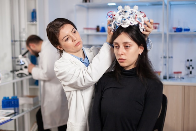 Neurolog W Nowoczesnej Klinice Przygotowujący Dla Pacjenta Zestaw Słuchawkowy Z Czujnikami Do Skanowania Mózgu Za Pomocą Zaawansowanego Technologicznie Urządzenia, Tomografii. Poszukiwanie Diagnozy Chorego Układu Nerwowego.