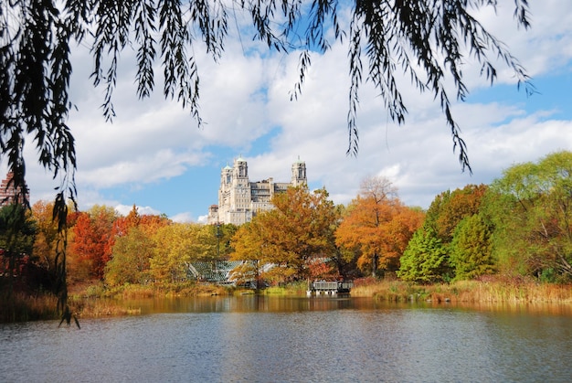 New York City Central Park jesienią z wieżowcami Manhattanu i kolorowymi drzewami nad jeziorem z odbicia.