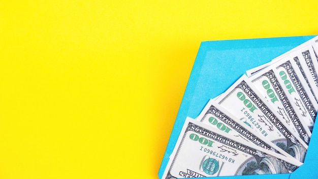 Niebieska koperta z pieniędzmi na żółtym tle