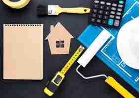 Bezpłatne zdjęcie niebieski nadruk domu z narzędziami i pustym notatnikiem