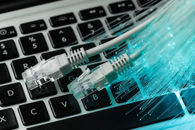 Bezpłatne zdjęcie niebieski światłowód z kablami ethernet i laptopem