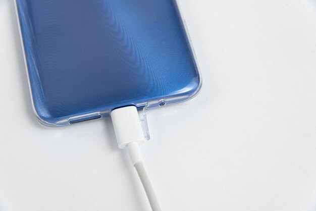 Niebieski telefon komórkowy podłączony do kabla USB typu C - Ładowanie