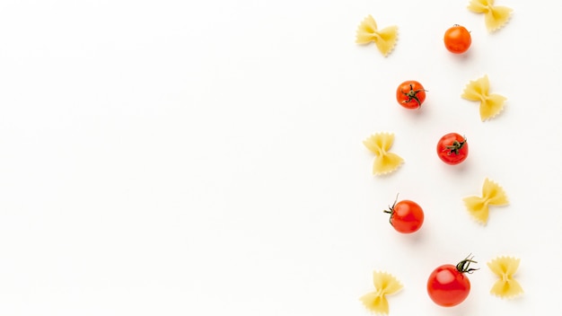 Niegotowane farfalle ustawienie z pomidorami z miejsca na kopię