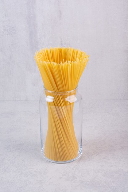 Niegotowany makaron spaghetti w szklanym słoju